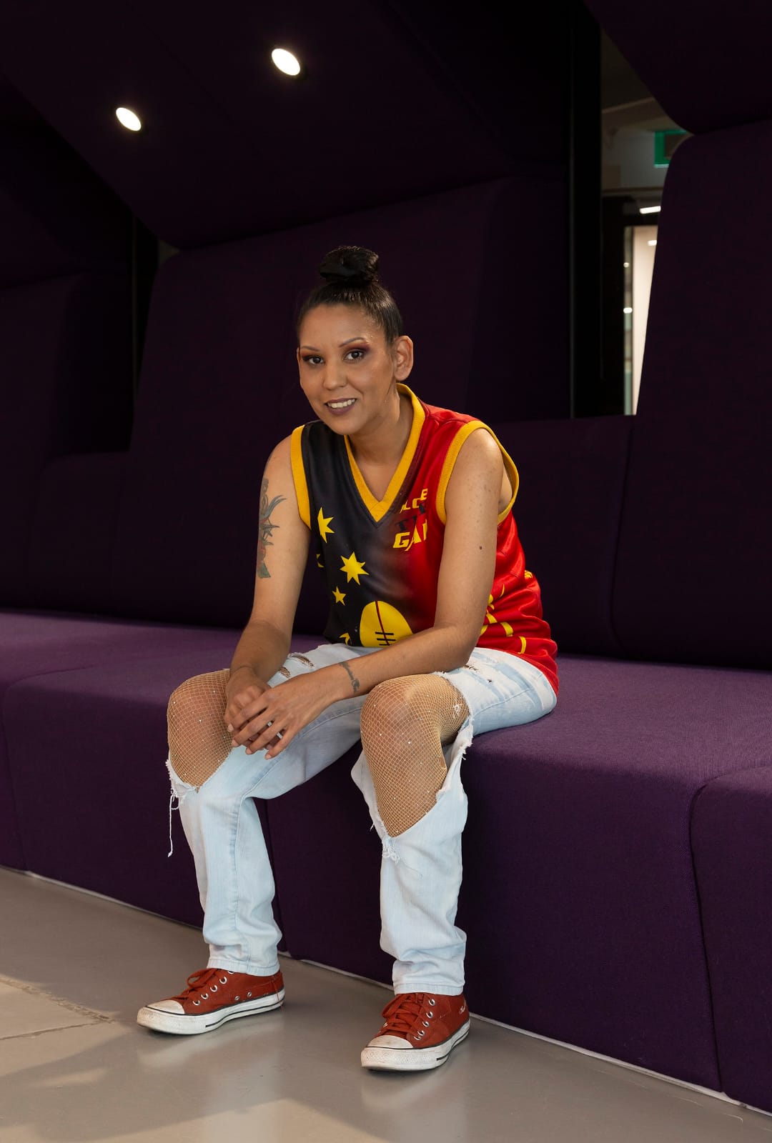 Tahnee seated in front of a dark purple wall